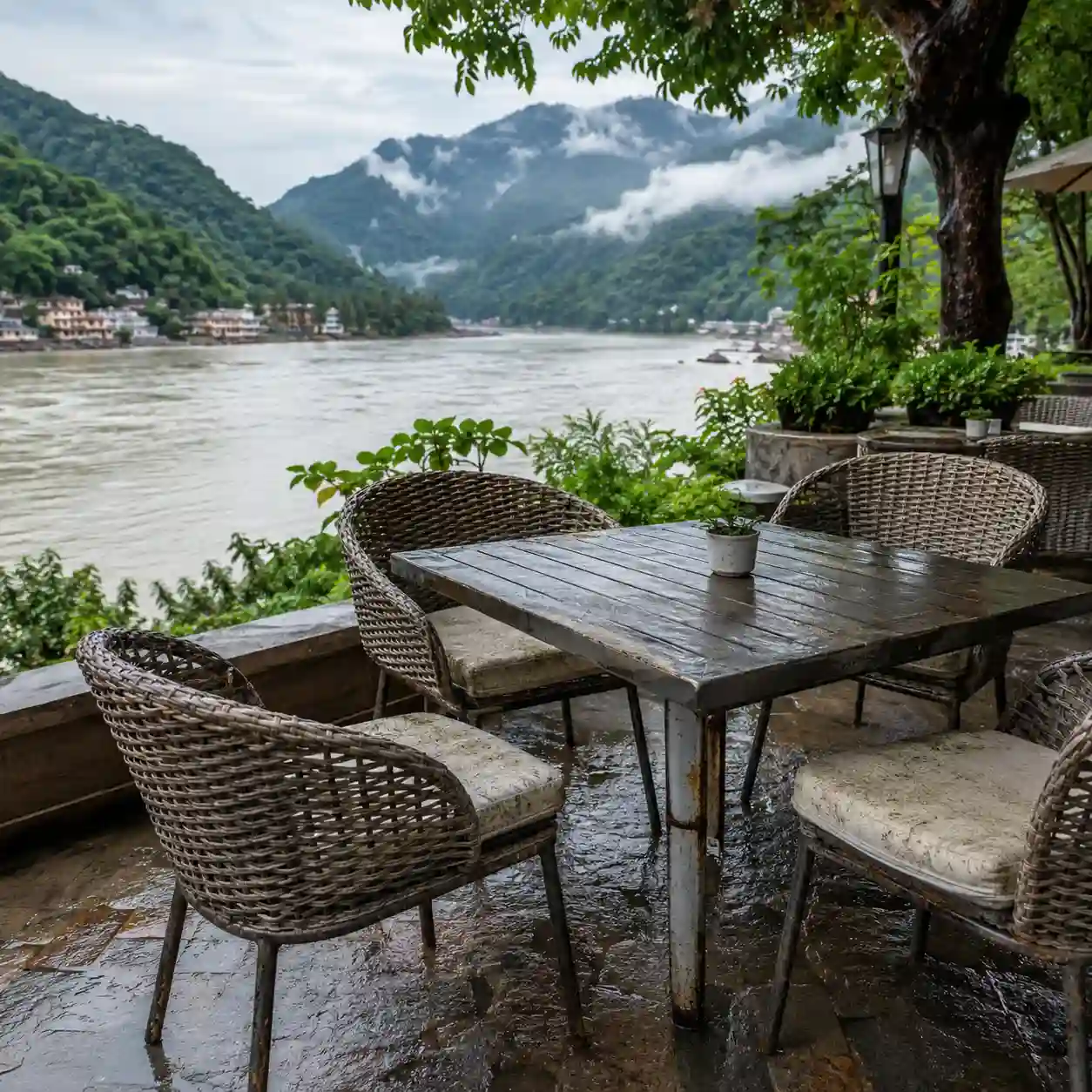 Green cushioned outdoor sofa set placed on a wooden deck overlooking a serene lake and hills.