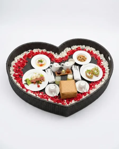 The Amora Heart Shaped Rattan Tray featuring a romantic silhouette and UV-stabilized synthetic rattan over an aluminum core.