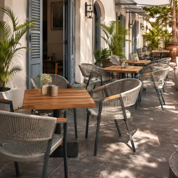 Outdoor rope-woven chairs and wooden tables by a premium Cafe Furniture Manufacturer Pondicherry.