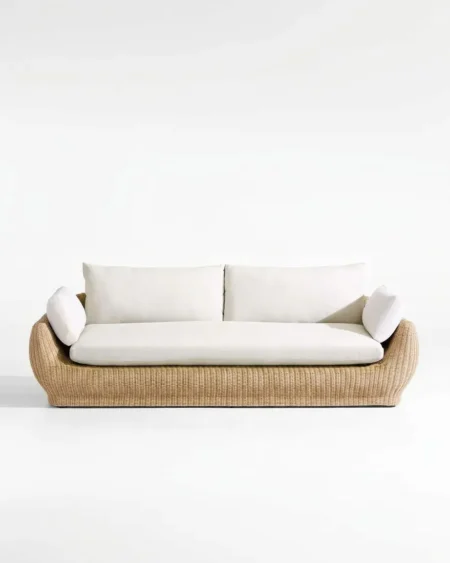 The Dune Curved Rattan Lounge Sofa featuring a sophisticated 3-seater design with an organic curved base natural rattan weave and white cushions.