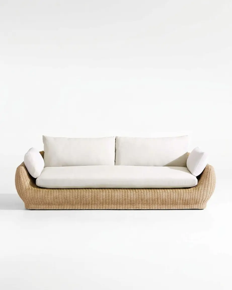 The Dune Curved Rattan Lounge Sofa featuring a sophisticated 3-seater design with an organic curved base natural rattan weave and white cushions.