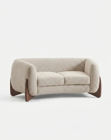 Luxury Kaldera Sculpted Boucle Sofa featuring a solid kiln-dried wood frame, dramatic exposed timber flanks, rounded pillow arms, and ivory boucle fabric for living rooms.