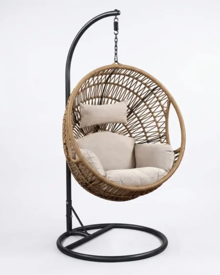 The Kavali Round Wicker Swing Chair featuring a tan rattan weave and a heavy-duty self-standing base.