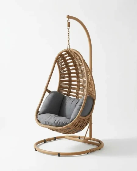 The Marbella Wicker Egg Swing Chair featuring a tan woven rattan cocoon and a rust-proof powder-coated stand.