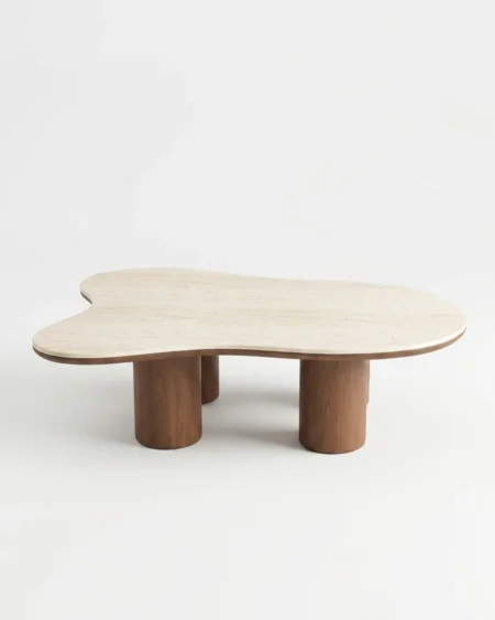 The Nimbus Travertine Cloud Table featuring an organic freeform stone top supported by cylindrical wood pedestal legs.